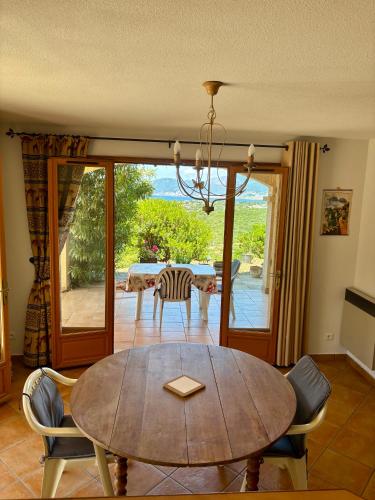 une salle à manger avec une table et une vue sur l'océan dans l'établissement Grand appartement vue mer Agosta, à Albitreccia