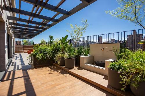 a patio with potted plants on a building at Condomínio Temple Batel | Gonzaga Stays in Curitiba