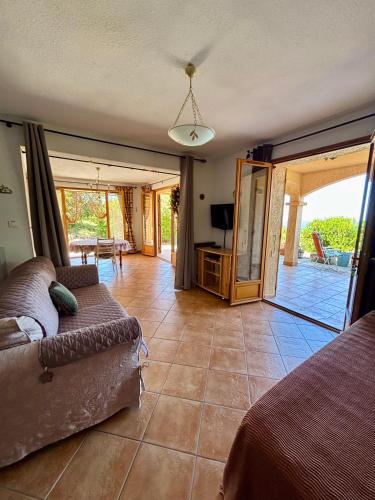 un salon avec un canapé et une terrasse dans l'établissement Grand appartement vue mer Agosta, à Albitreccia