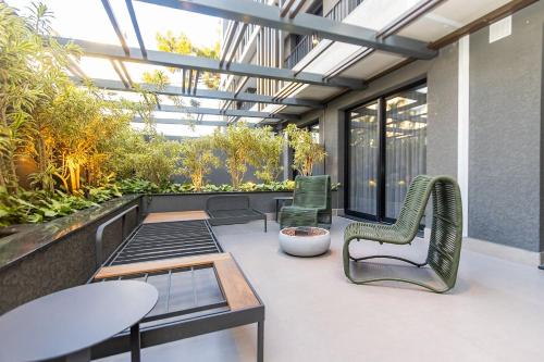 a patio with two chairs and a table and a table and chairsktop at Condomínio Temple Batel | Gonzaga Stays in Curitiba