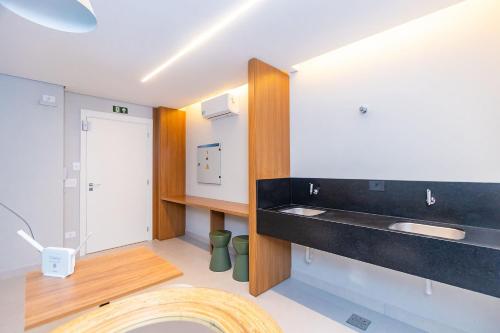a bathroom with a black counter and a sink at Condomínio Temple Batel | Gonzaga Stays in Curitiba