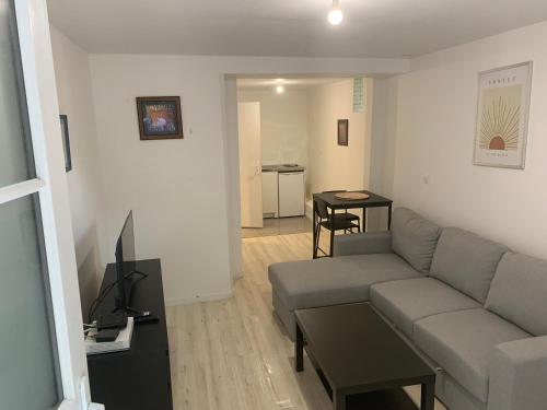 un salon avec un canapé et une table dans l'établissement Studio cosy proche gare des Mureaux, aux Mureaux