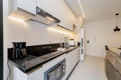 a kitchen with a sink and a counter top at Condomínio Temple Batel | Gonzaga Stays in Curitiba