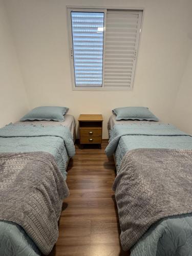 a room with two beds and a window at Edifício Forte dos Lagos in Toledo