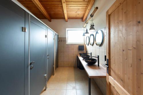 a bathroom with two sinks and a counter with mirrors at La Bohème Lodges and Glamping in Vrhaveč