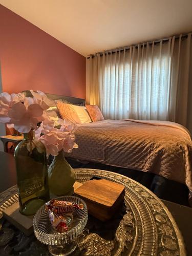 a bedroom with a bed and a table with flowers on it at Sweet Dreams in Middelburg