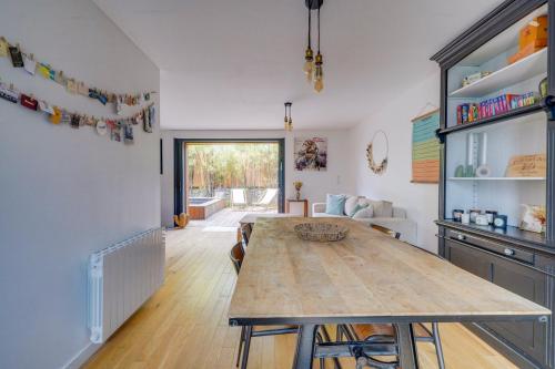 une cuisine et une salle à manger avec une table en bois dans l'établissement La maison du port – Maison avec piscine à La Teste, à La Teste-de-Buch