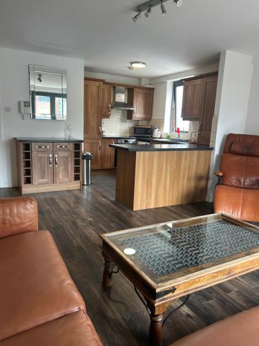 a kitchen with a couch and a table in a room at Large 2 bedroom 2 bathroom x6 person city center apartment with free underground parking in Belfast