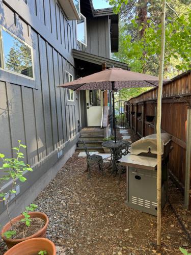 a patio with a grill and an umbrella on a house at Lake Tahoe Luxury Guest Quarters in South Lake Tahoe