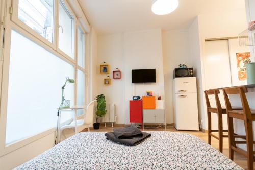 a room with a table and a refrigerator at Retro Pop in Angers