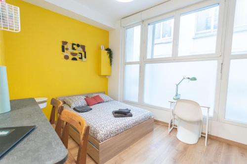a small bedroom with a bed and a table at Retro Pop in Angers