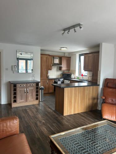 a kitchen with wooden cabinets and a counter top at Large 2 bedroom 2 bathroom x6 person city center apartment with free underground parking in Belfast