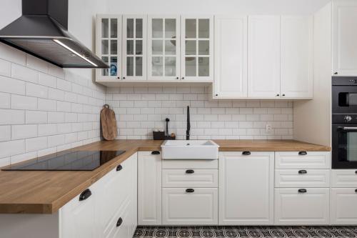 a white kitchen with white cabinets and a sink at Apartment Nina in Bakar
