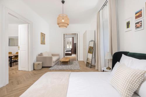 a white bedroom with a bed and a living room at Apartment Nina in Bakar