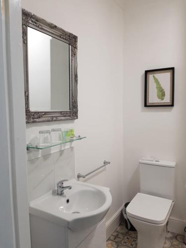 a white bathroom with a sink and a toilet at The Willows B&B in Bolsover