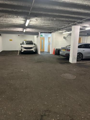 a parking garage with two cars parked in it at Large 2 bedroom 2 bathroom x6 person city center apartment with free underground parking in Belfast