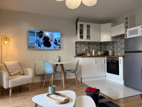 Il comprend un salon avec une cuisine et une télévision murale. dans l'établissement Le Bleu Marine, grand studio au calme, à 2 pas du lac !, à Gérardmer