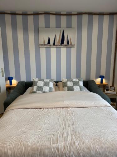 a bedroom with a bed with two sails on the wall at Le Bleu Marine, grand studio au calme, à 2 pas du lac ! in Gérardmer