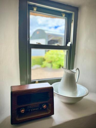 a radio and a vase on a table next to a window at Murphys Thatched Cottage in Mitchelstown