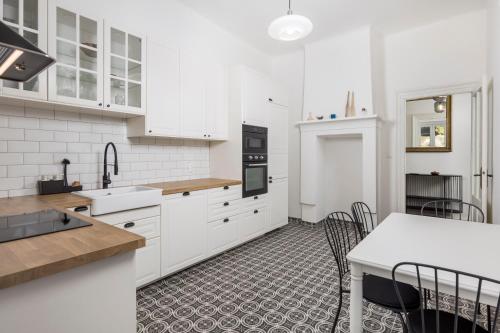 a kitchen with white cabinets and a table with chairs at Apartment Nina in Bakar