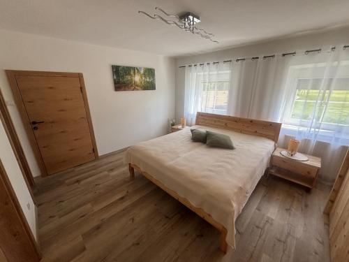 a bedroom with a large bed and a window at Gästehaus zum Alpenjäger 