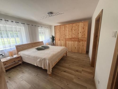 a bedroom with a bed and a large window at Gästehaus zum Alpenjäger 