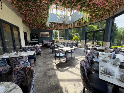 a dining room with tables and chairs and flowers at The Mount Country Manor Hotel & Golf Wolverhampton in Wolverhampton
