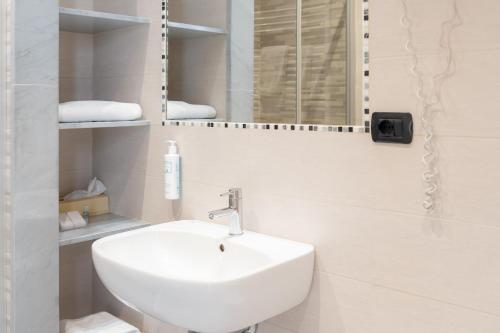 a white bathroom with a sink and a mirror at Hotel Florida Lerici in Lerici