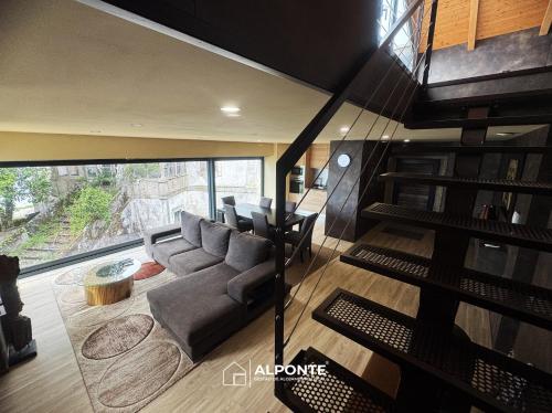a living room with a couch and a staircase at Varanda do Cais BY ALPONTE in Caminha