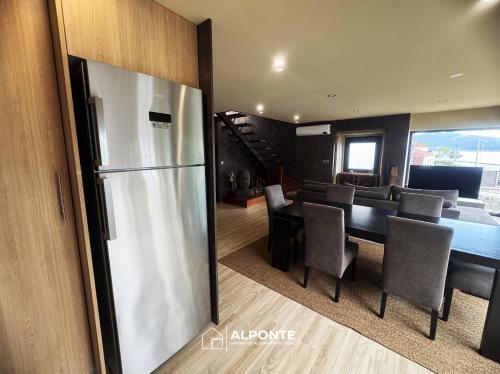 a kitchen and dining room with a stainless steel refrigerator at Varanda do Cais BY ALPONTE in Caminha