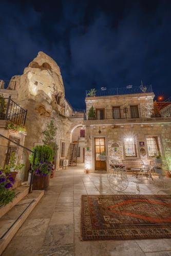 a large stone building with a courtyard at night at Zara Cave Hotel in Goreme