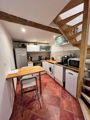 - une cuisine avec une table en bois et un comptoir dans l'établissement Appartement T3 avec jardin, à Toulon
