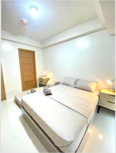 a bedroom with a large white bed in a room at Climax Point Apt in Mandaue City