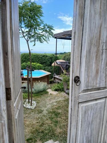 une porte ouverte menant à une arrière-cour avec une piscine dans l'établissement les cerisiers de stella, à Blauvac