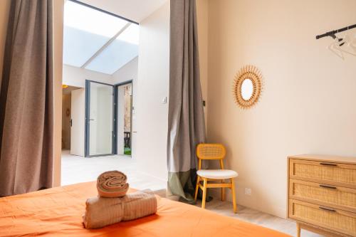 une chambre avec un lit, une commode et une chaise dans l'établissement Magnifique appartement avec terrasse, à Bordeaux