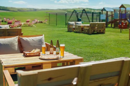 a picnic table with beer and bread and a playground at Biała Akacja Resort & Business in Prudnik