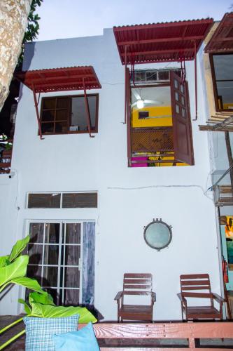 two windows on a white building with chairs in it at Hotel Restaurant Wuarao - Antiguo Club Rolling Stones in Boca Chica