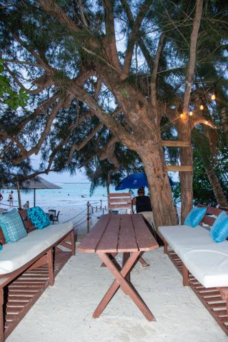 a picnic table and chairs under a tree on the beach at Hotel Restaurant Wuarao - Antiguo Club Rolling Stones in Boca Chica