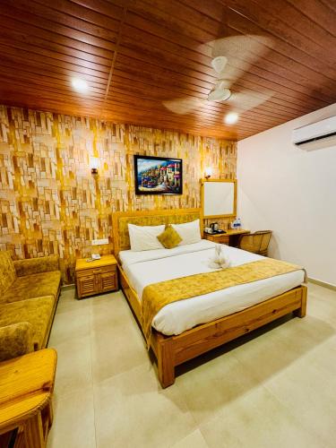 a bedroom with a large bed and a couch at Maargit Beach Resort in Mandrem