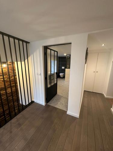 an empty living room with a door and wooden floors at UrbanNEST in Michelau