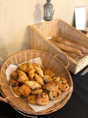 un panier de pâtisseries sur une table avec une corbeille de pain dans l'établissement Hôtel de l Héritage, à Crannes-en-Champagne