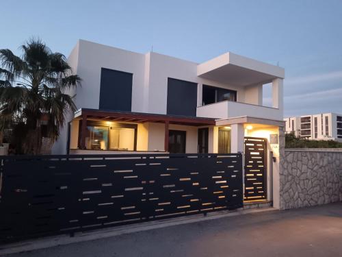 a white house with a black fence at Kuća za odmor MARIA in Vodice