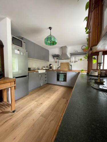 cocina grande con suelo de madera y electrodomésticos de acero inoxidable en Villa Småland-Edles Naturidyll bei Berlin, en Glienicke