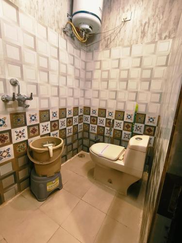 a bathroom with a toilet and a sink at Hotel Pardesi,Har ki pauri Road Haridwar in Haridwār