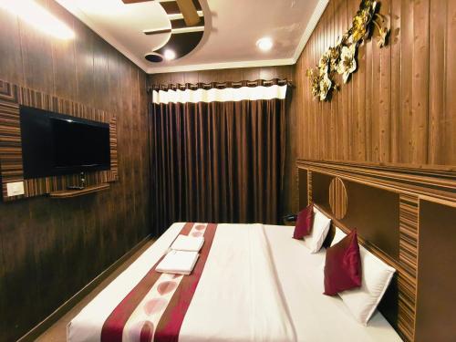 a hotel room with a bed and a flat screen tv at Hotel Pardesi,Har ki pauri Road Haridwar in Haridwār