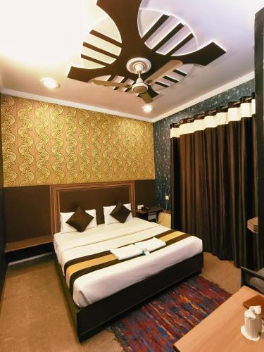 a bedroom with a bed with a ceiling fan at Hotel Pardesi,Har ki pauri Road Haridwar in Haridwār