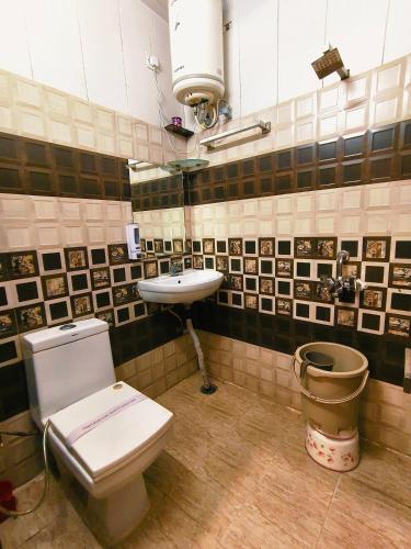 a bathroom with a toilet and a sink at Hotel Pardesi,Har ki pauri Road Haridwar in Haridwār