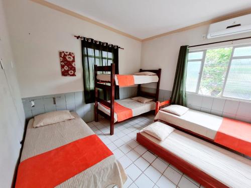 a room with three bunk beds and a window at São luís Hostel in São Luís