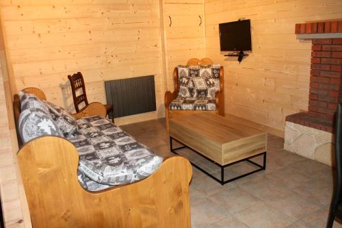 un salon avec un canapé, une table et une télévision dans l'établissement Gîte des vergnioux, à Ayat-sur-Sioule