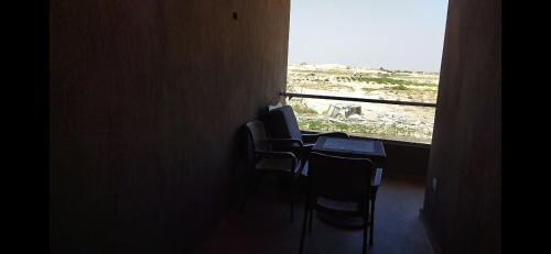 a room with a table and chairs and a window at grand hills in Dawwār ‘Abd Allāh